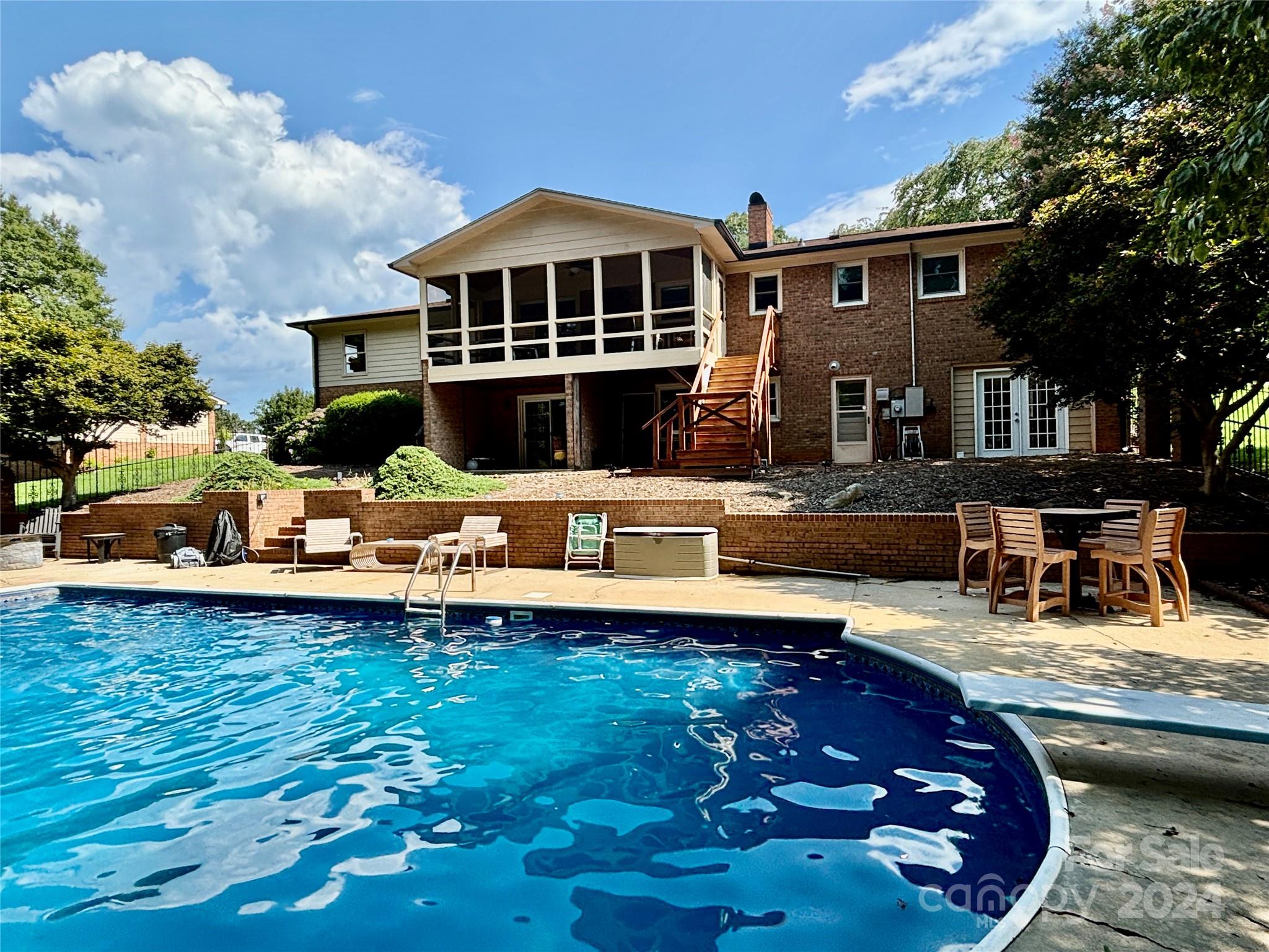 a swimming pool view with a seating space and a garden view