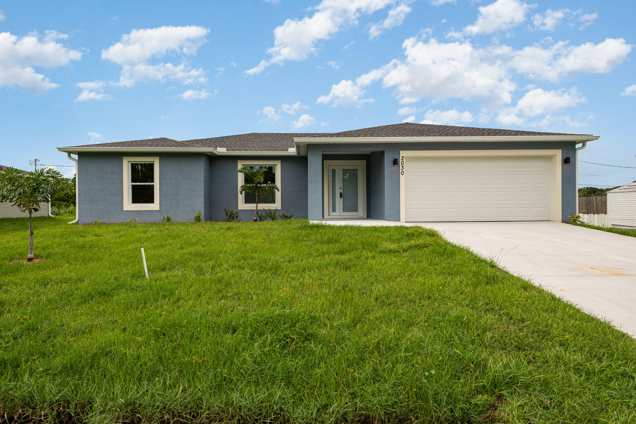 a front view of a house with yard and garage