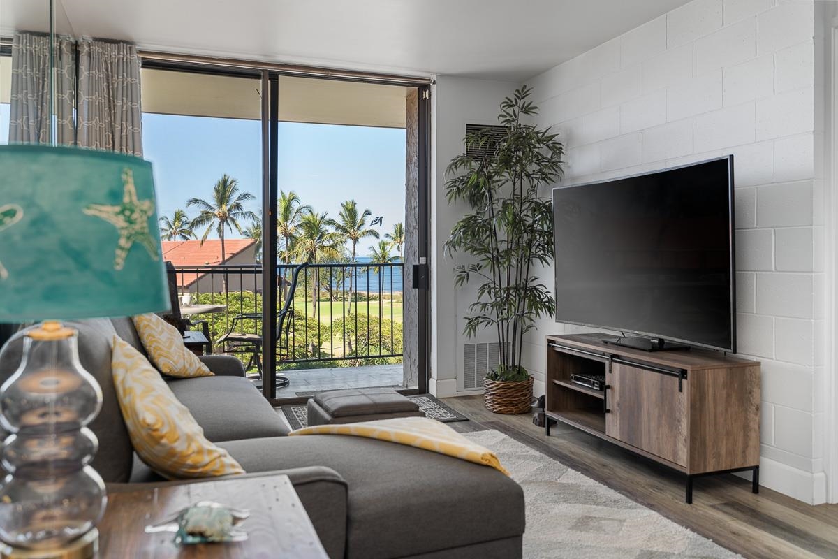 a living room with furniture a flat screen tv and a floor to ceiling window