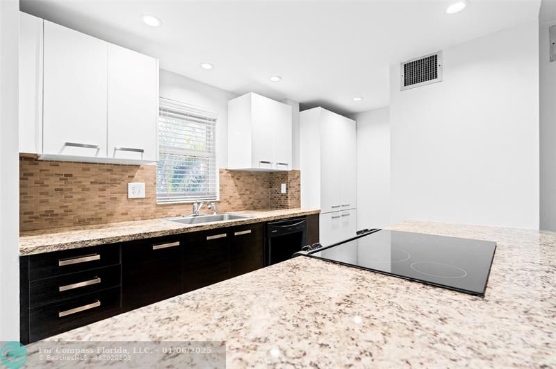 a kitchen with a sink a stove and cabinets