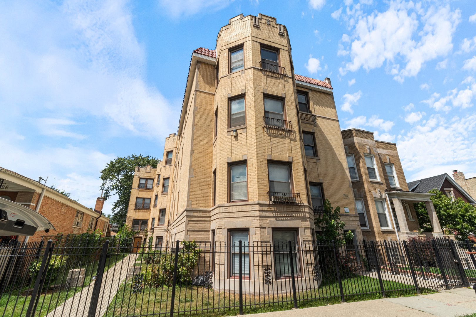 a front view of a residential apartment building with a yard