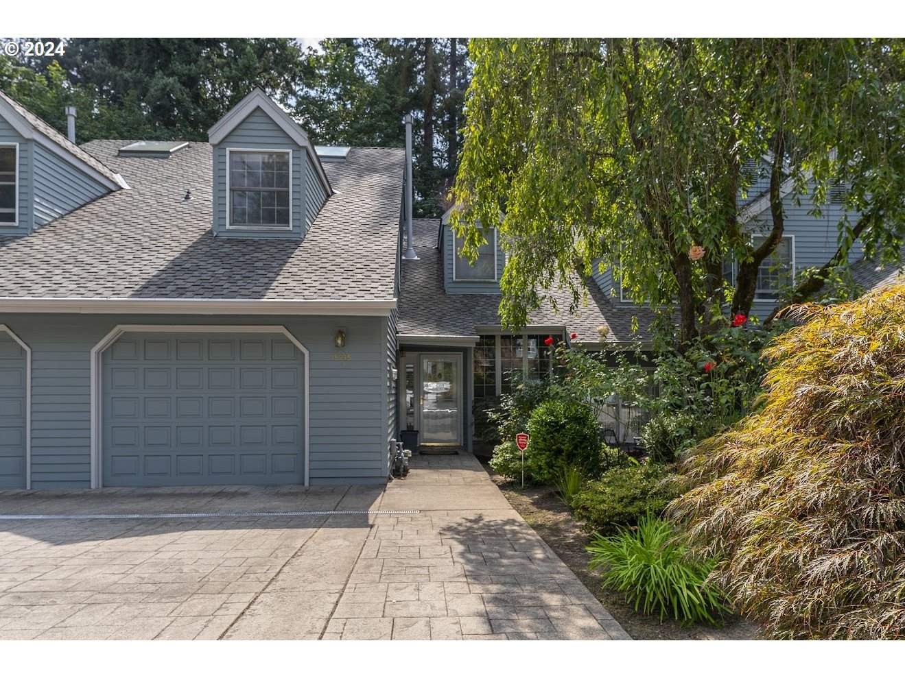 a front view of a house with a garden