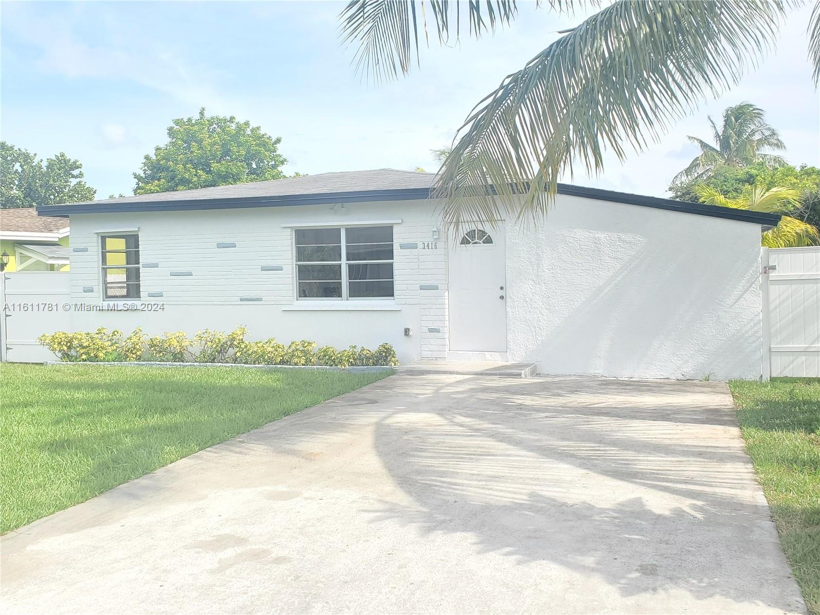 a front view of house with yard and trees around