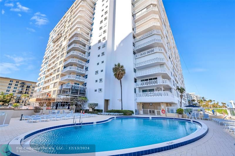 a view of building with swimming pool and porch