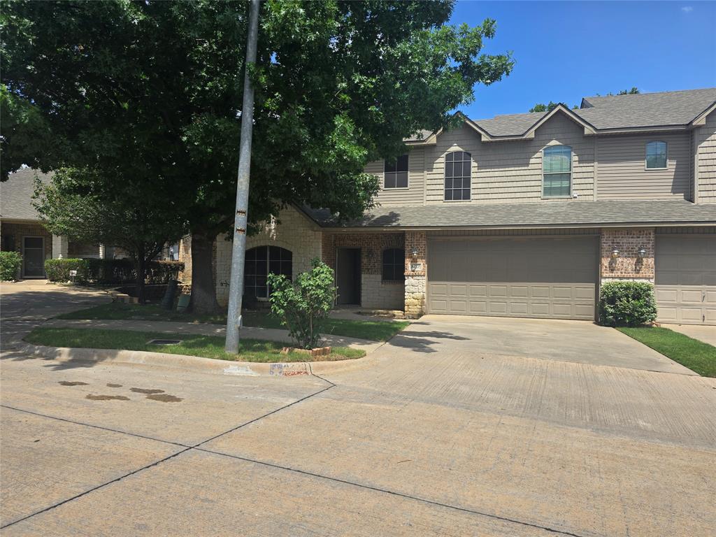 a front view of a house with a yard and trees