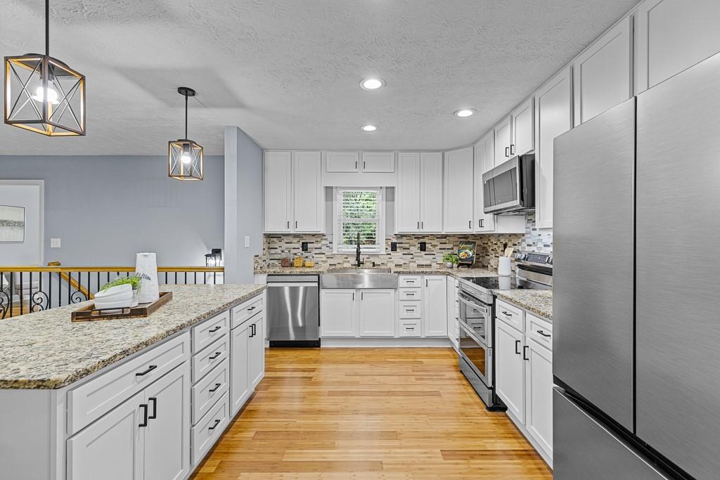 a kitchen with kitchen island granite countertop appliances cabinets and a counter space