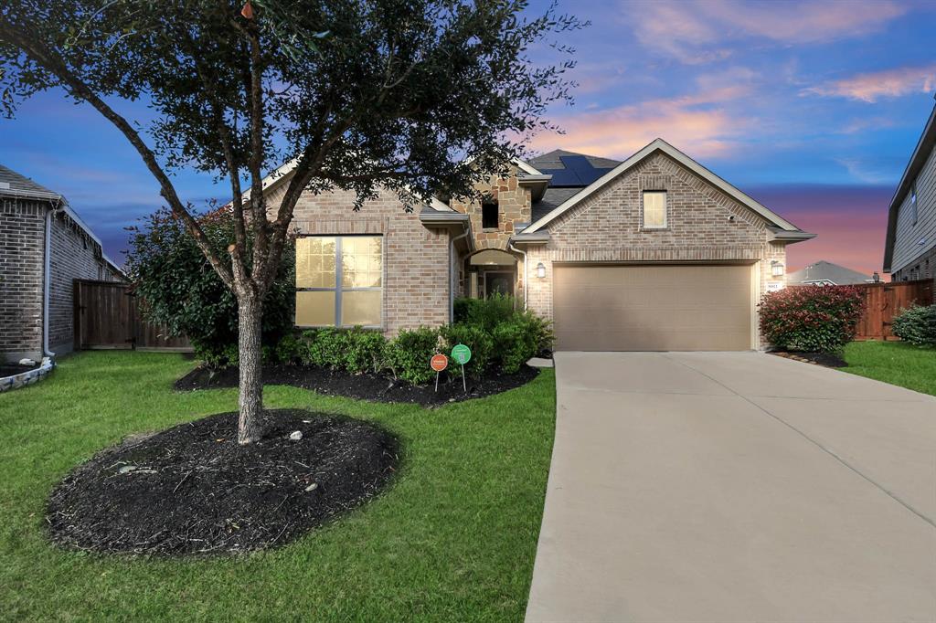 a front view of a house with a garden and trees