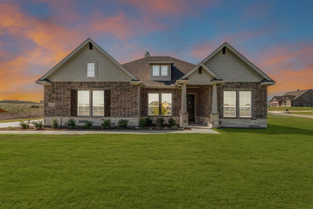 a front view of a house with a garden and yard