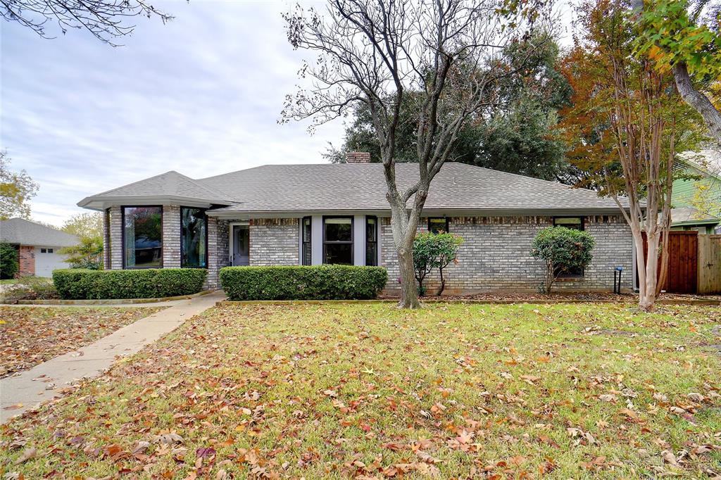 a front view of a house with a garden and yard