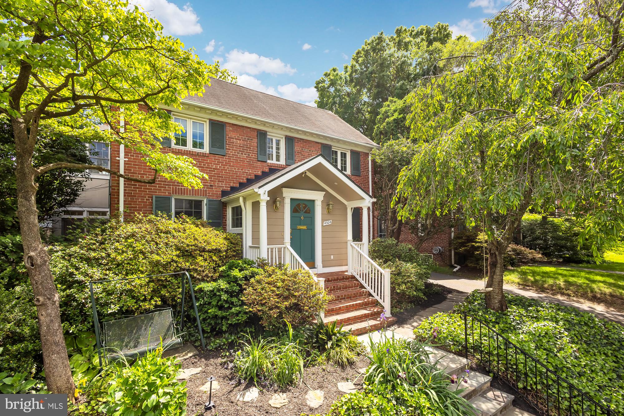 a front view of a house with a yard and potted plants