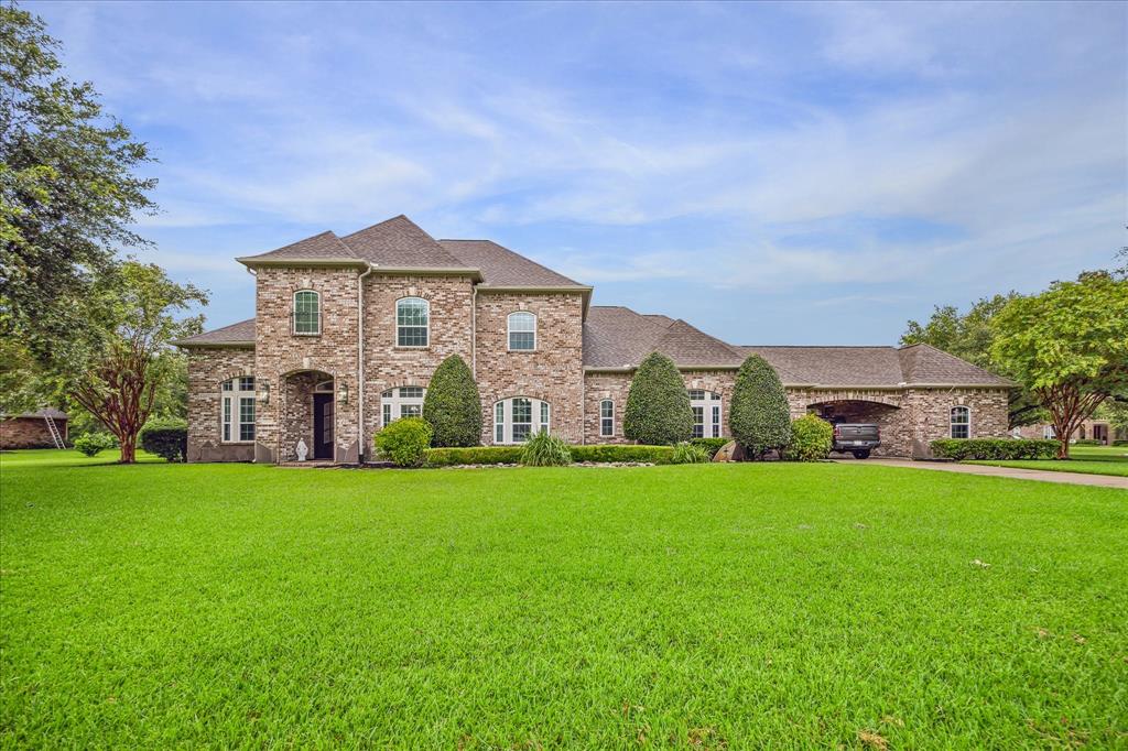 THIS BRICK ESTATE FEATURES A 3-CAR GARAGE AND PORTE COCHERE.