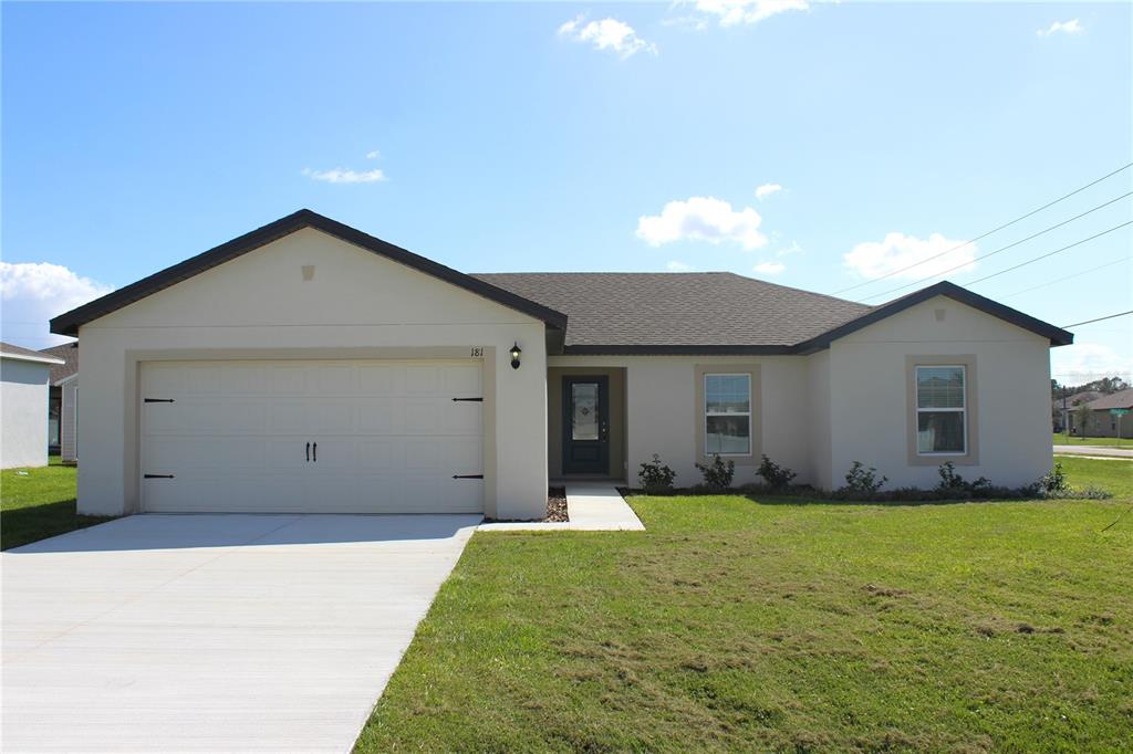 a front view of house with yard and garage