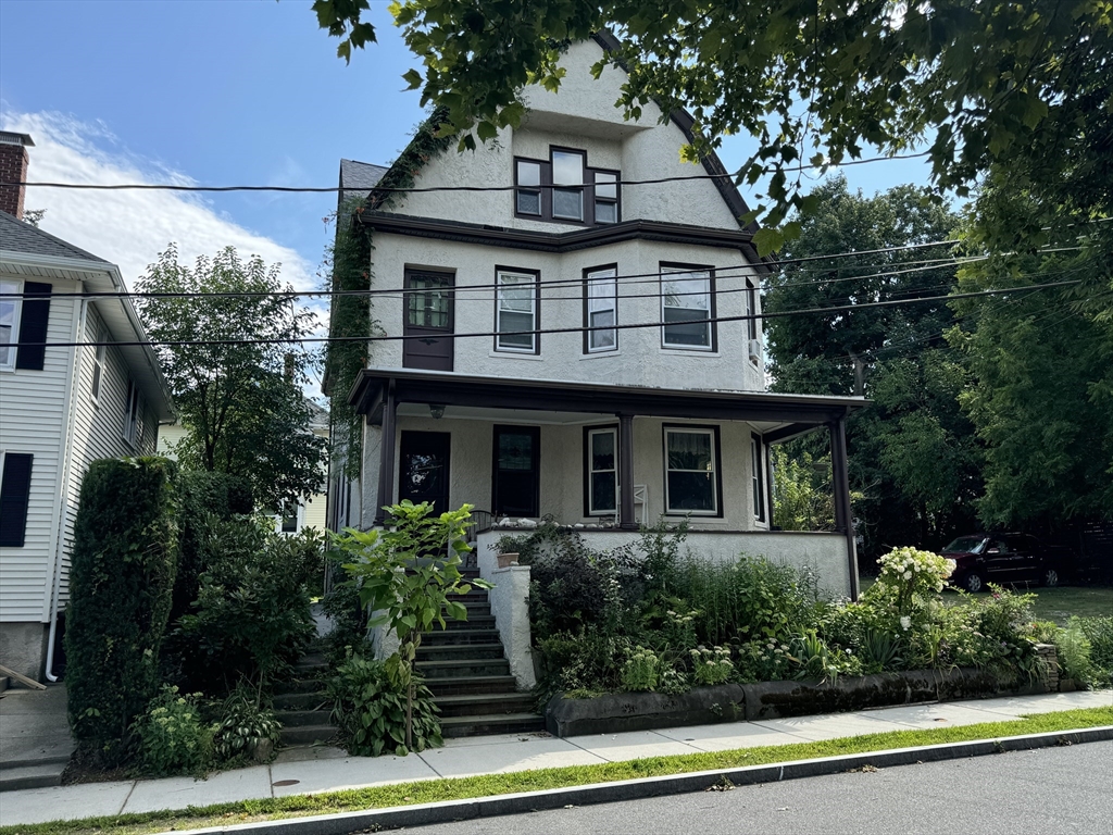 a front view of a house with plants and entryway