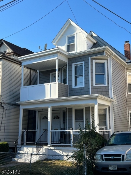 a view of a white house with large windows and a small yard