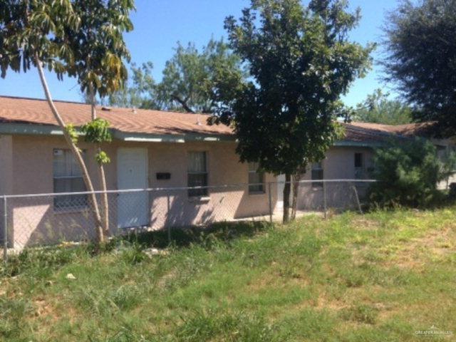 a view of a house with backyard and a tree