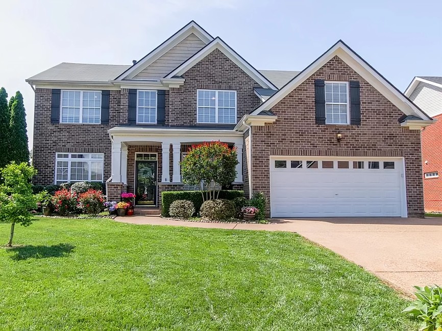 a front view of a house with a yard and garage