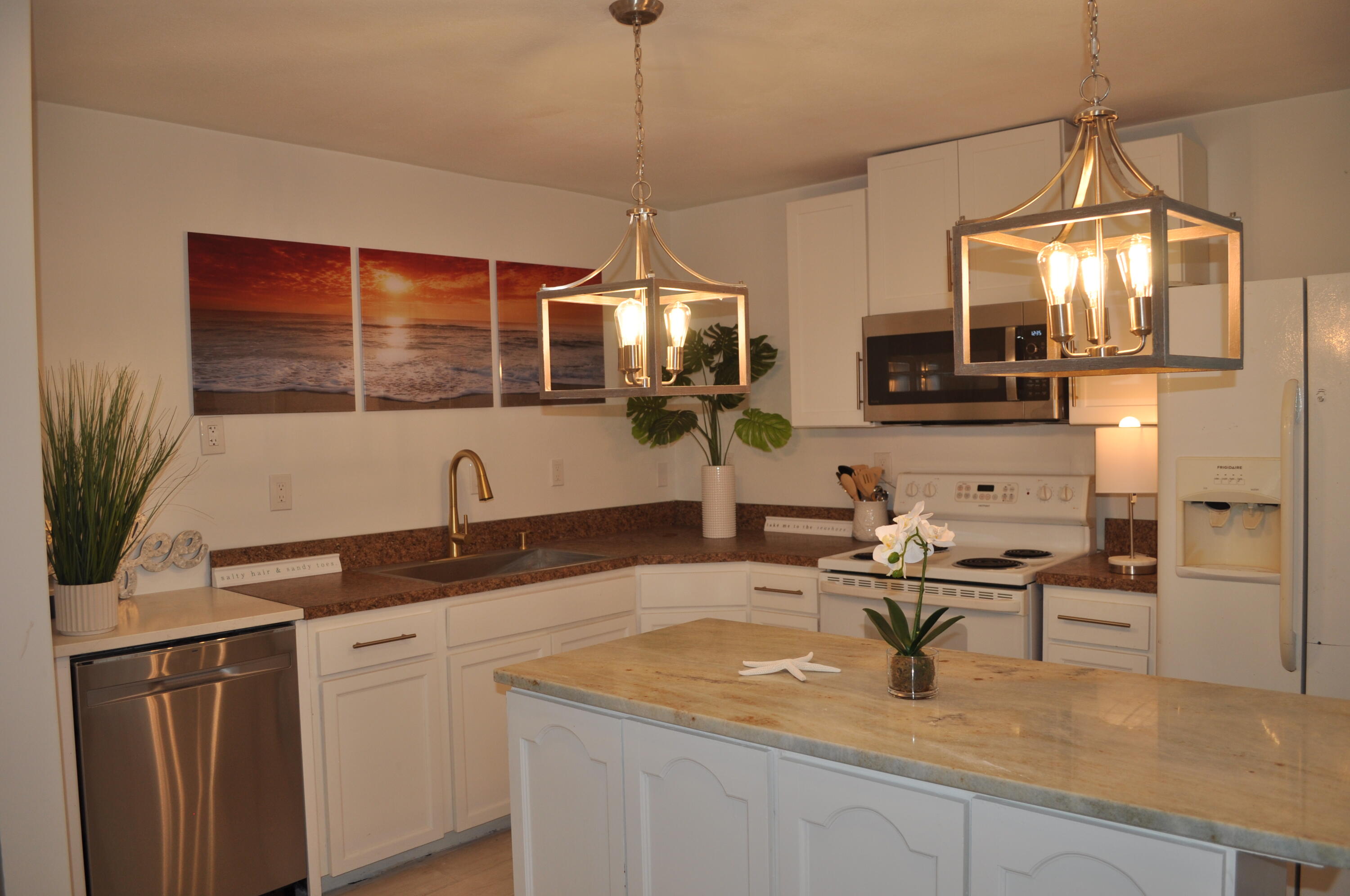 a kitchen with a sink a counter top space cabinets and stainless steel appliances