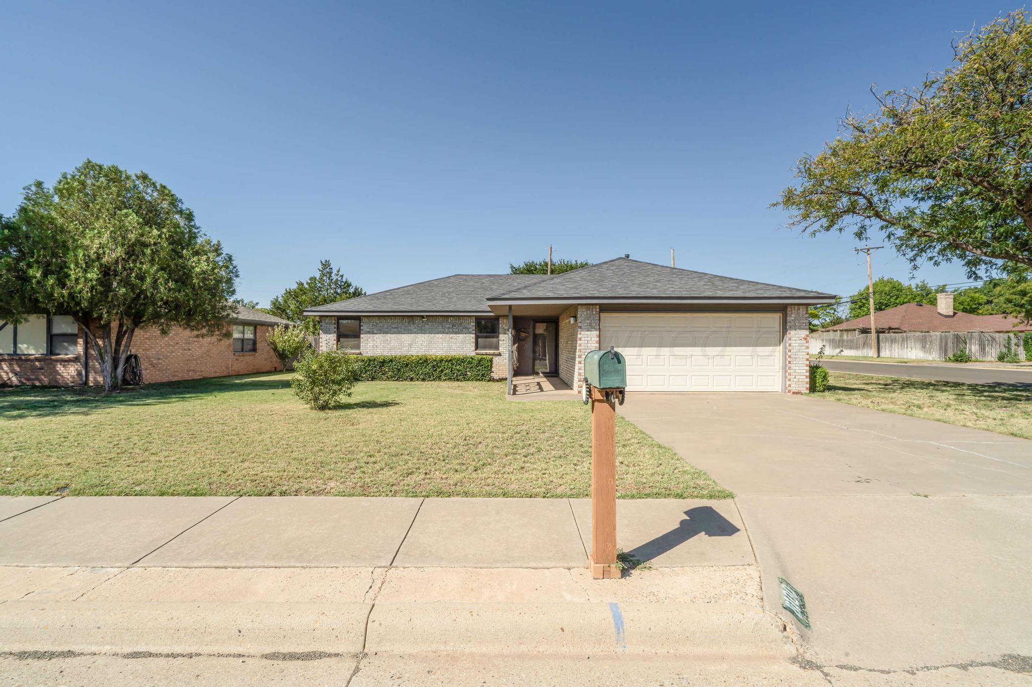 a front view of a house with a garden and yard