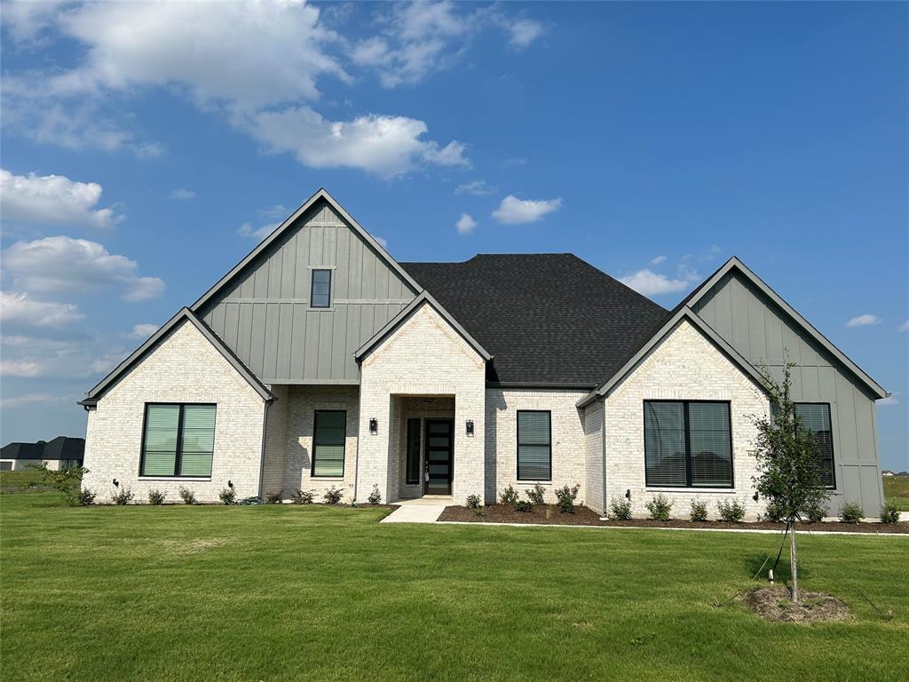 a front view of a house with a garden and yard