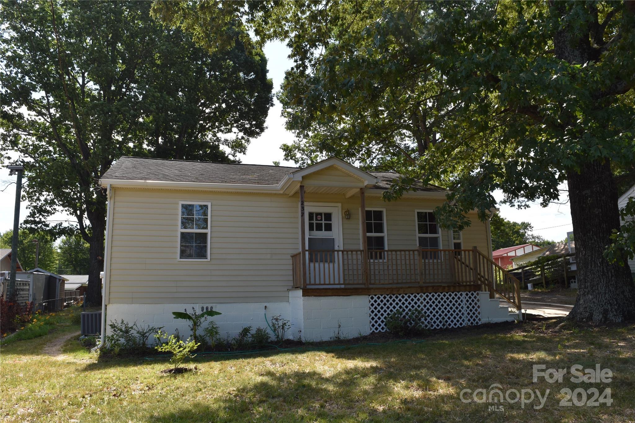 a view of a house with a large tree and a yard