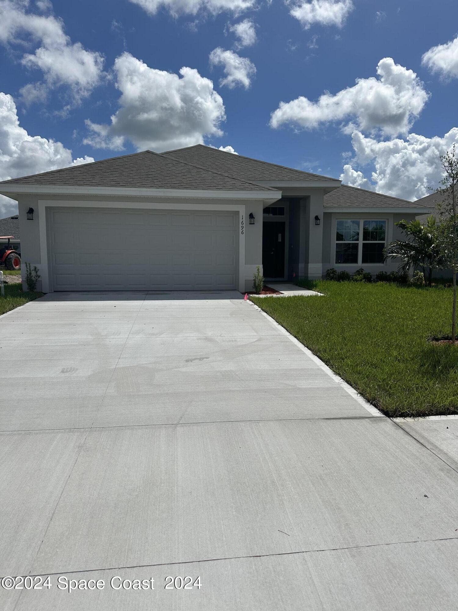 a front view of a house with a yard and a garage