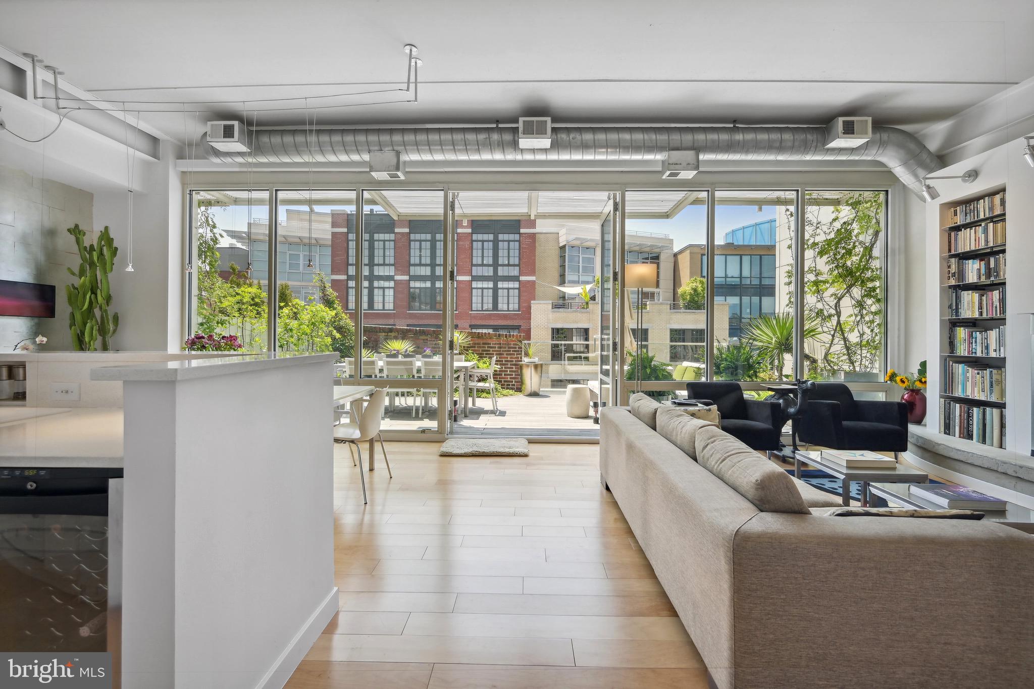 a living room with couches a coffee table and a large window with garden view