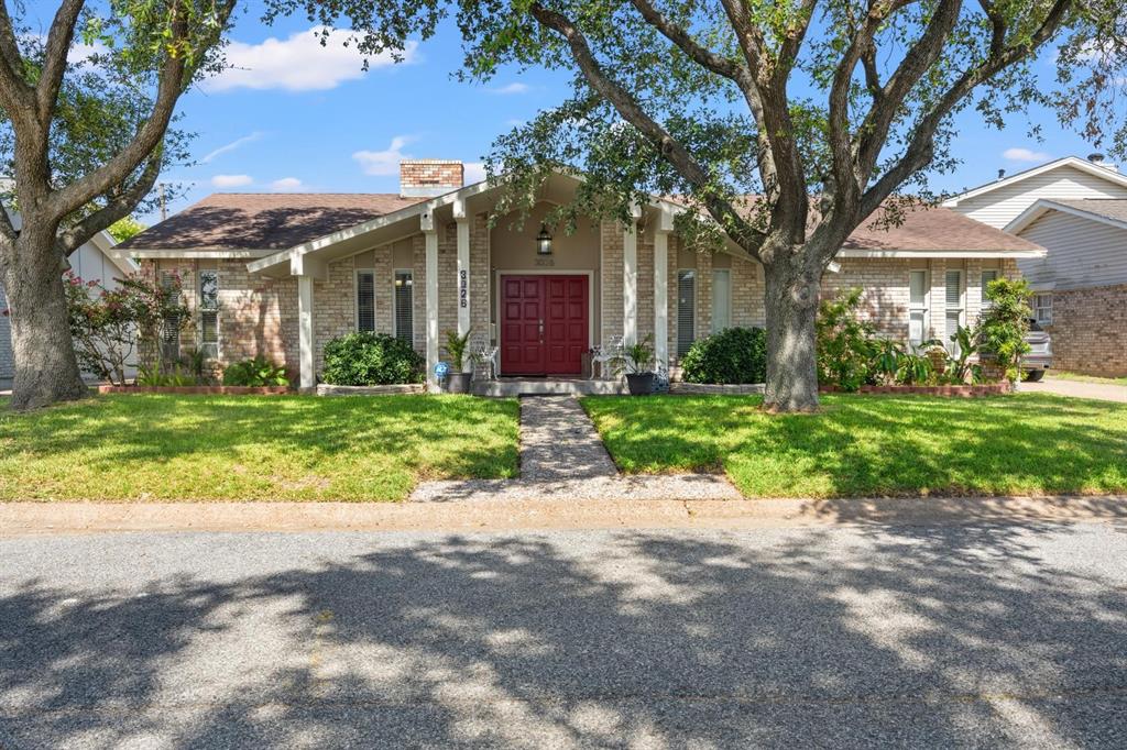 a view of a house with a tree in front of it