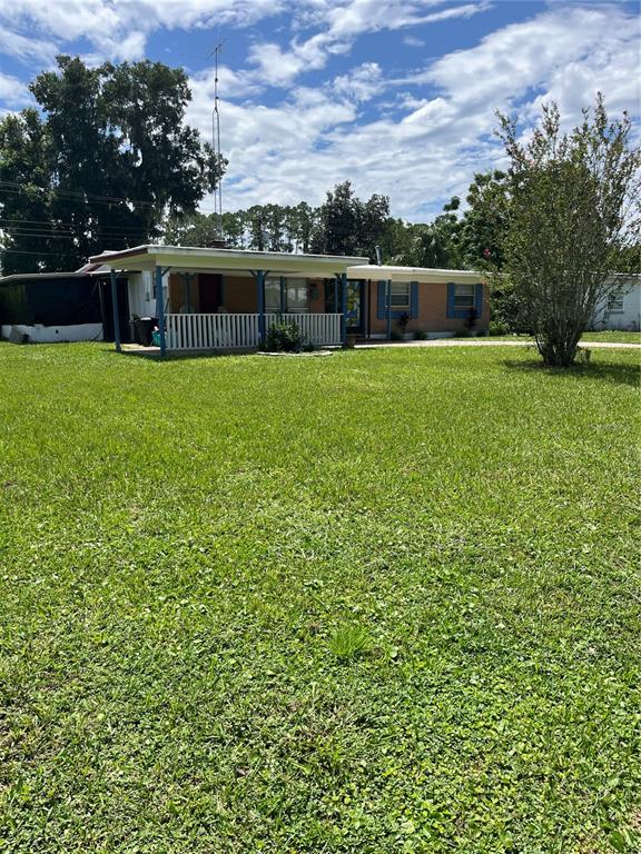 a view of house with a yard