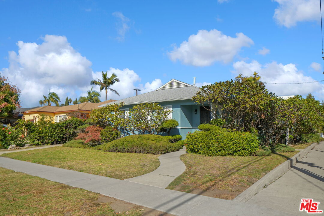 a front view of a house with a yard and a garden