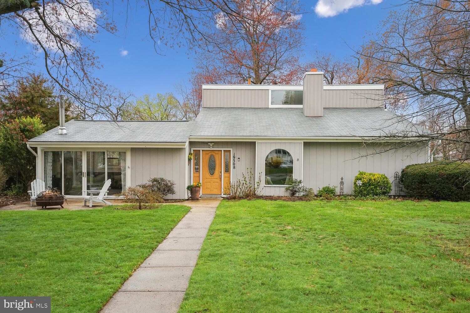 a front view of a house with a yard and trees