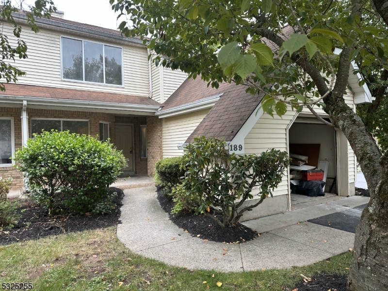 a view of a house with brick walls and a tree