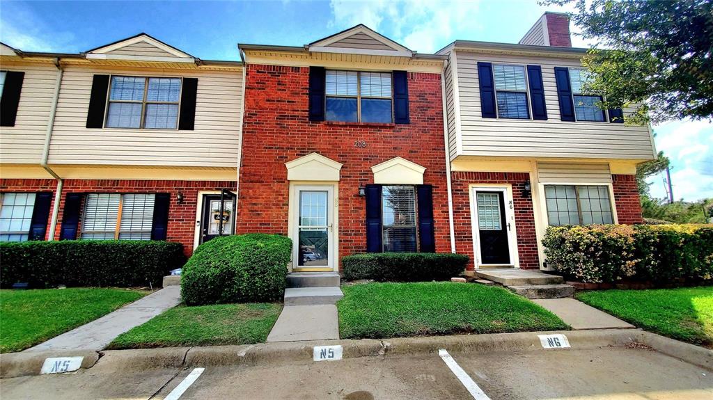 front view of a brick house with a yard