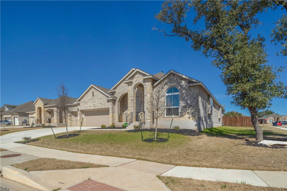 a view of a large house with a yard and large trees