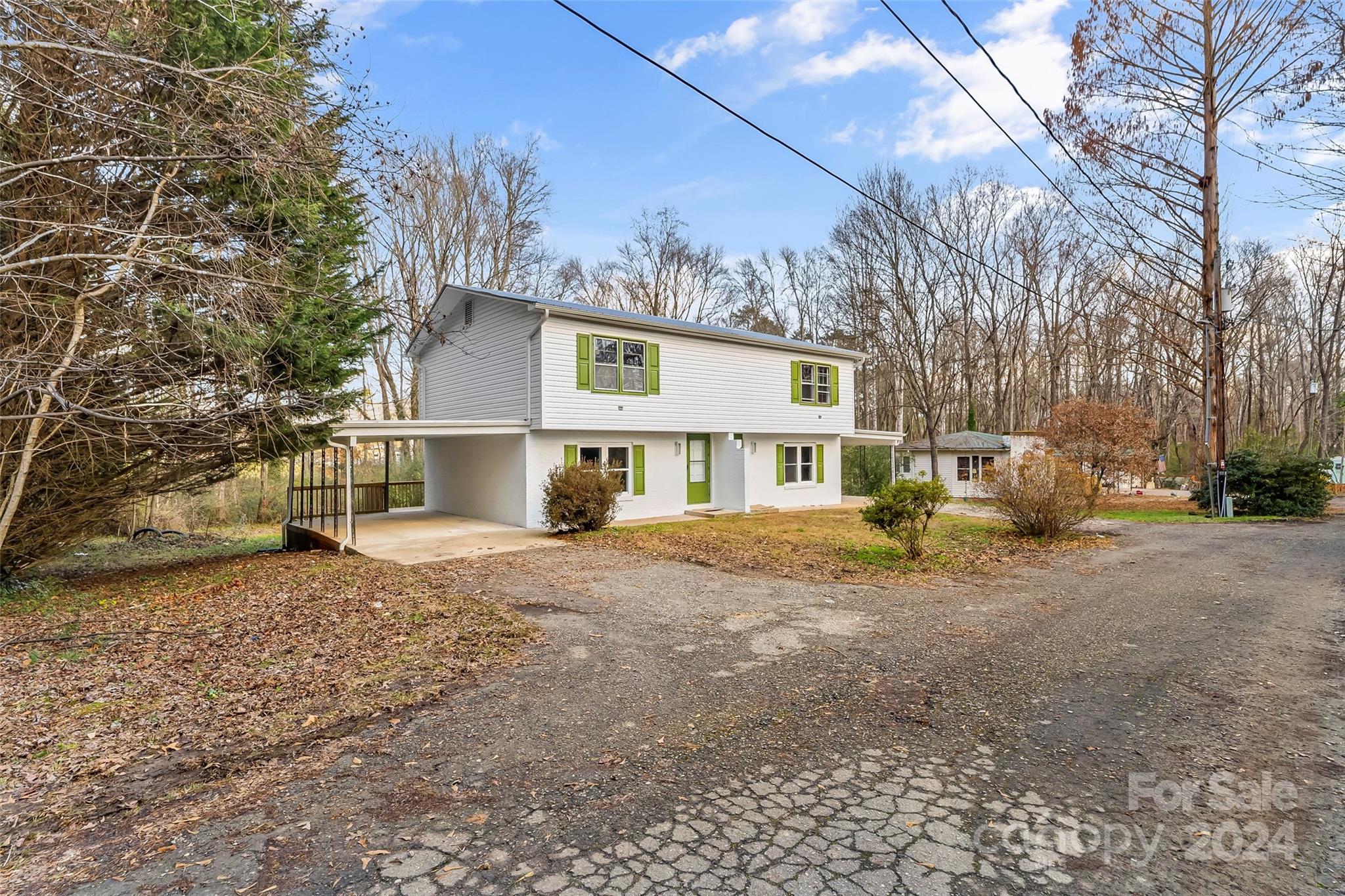 a view of a house with a yard and large tree