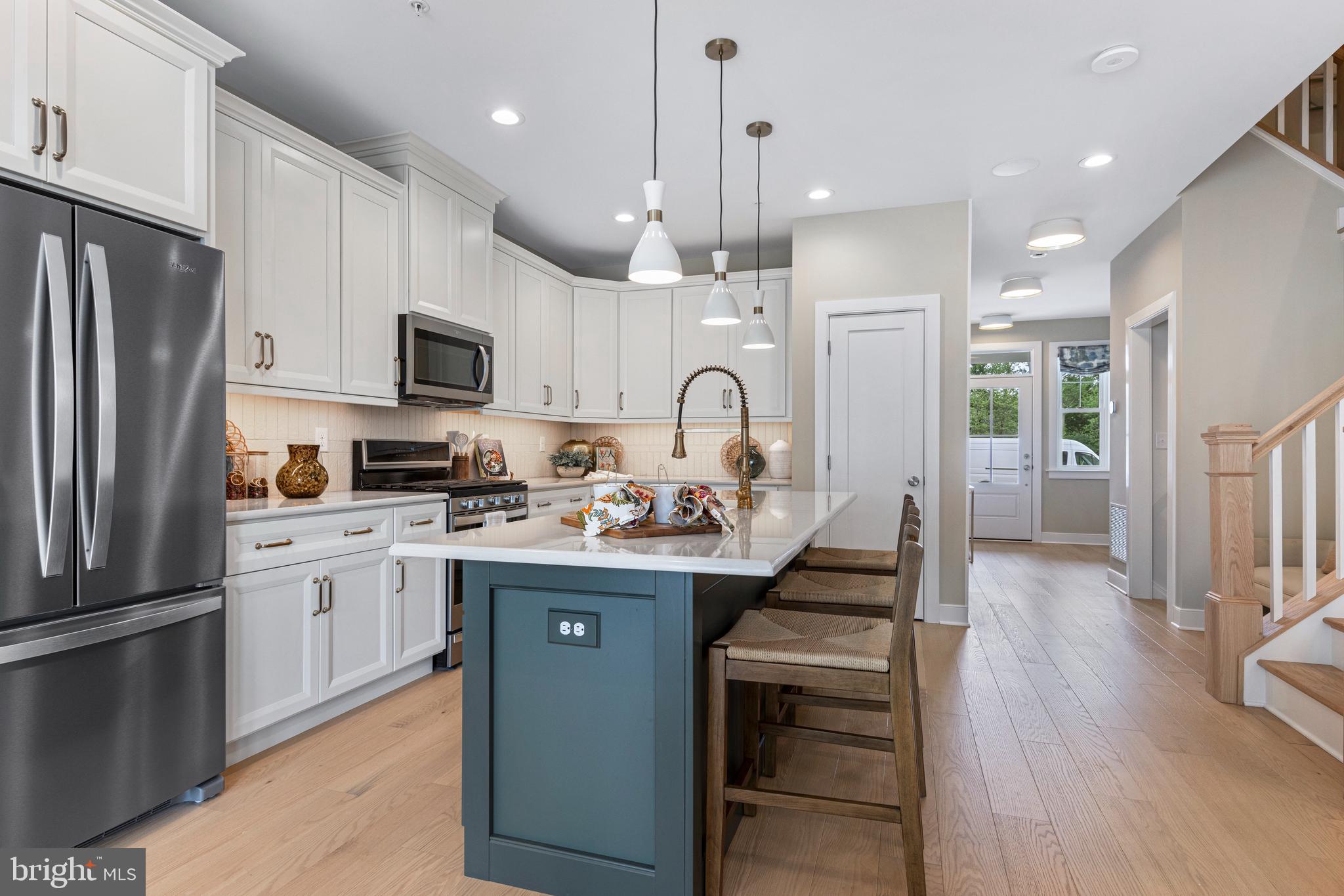 a kitchen with kitchen island granite countertop stainless steel appliances cabinets a sink and a counter top space