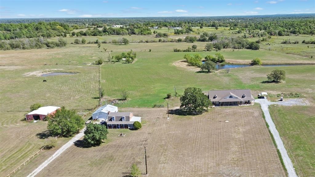 This serene countryside estate spans 82 acres and features a main home, a full guest or second home, a barn, a workshop, and a tranquil pond.