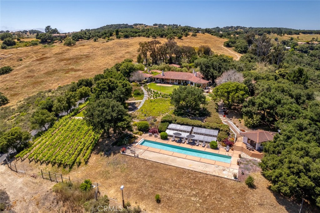 an aerial view of residential houses with outdoor space and trees