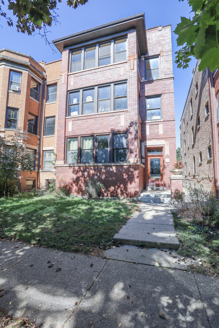 a front view of a residential apartment building with a yard