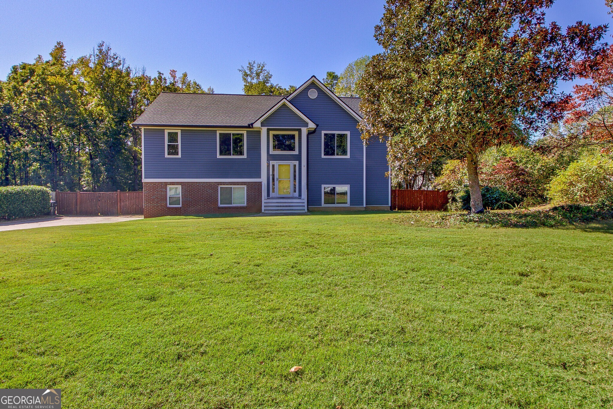 a front view of a house with yard and green space