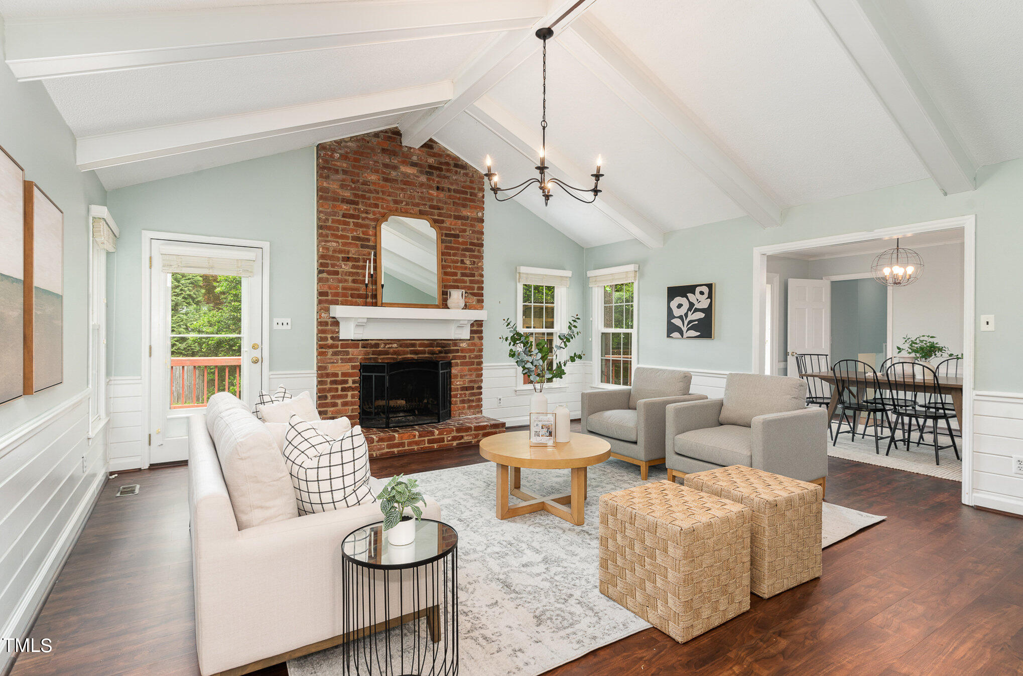 a living room with furniture a fireplace and a chandelier