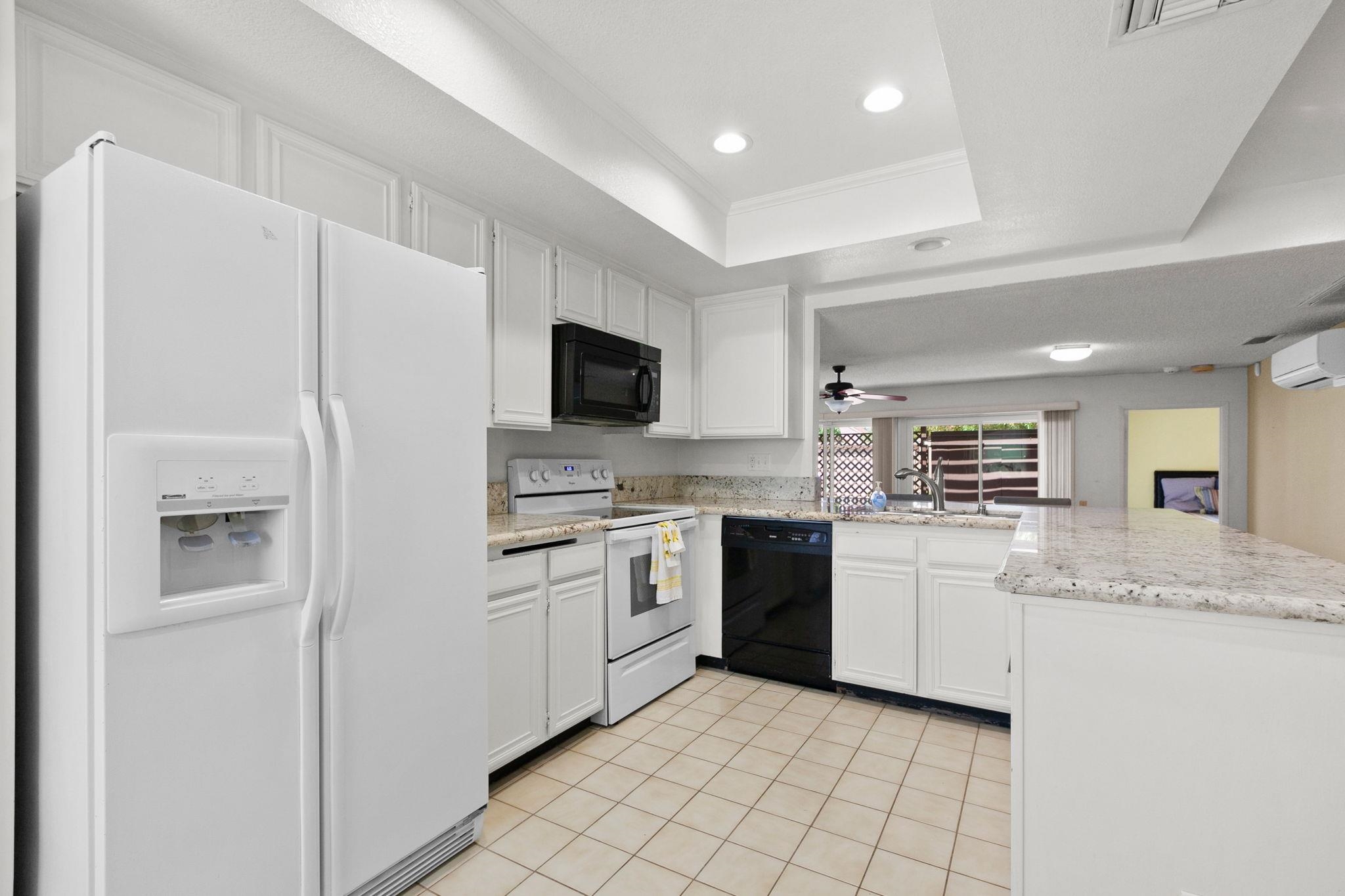 a kitchen with granite countertop a sink stainless steel appliances and cabinets