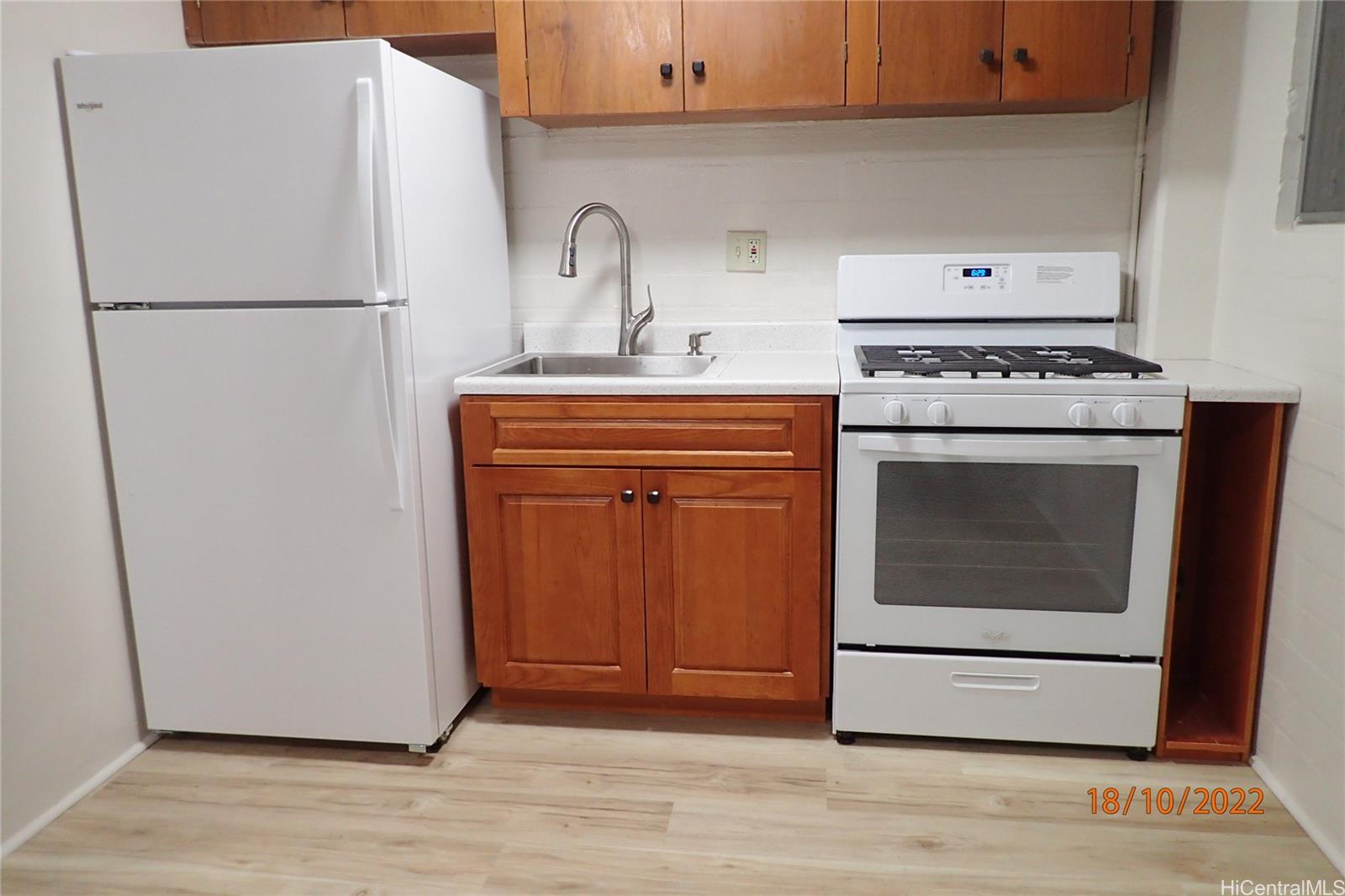 a white refrigerator freezer and a wooden floor