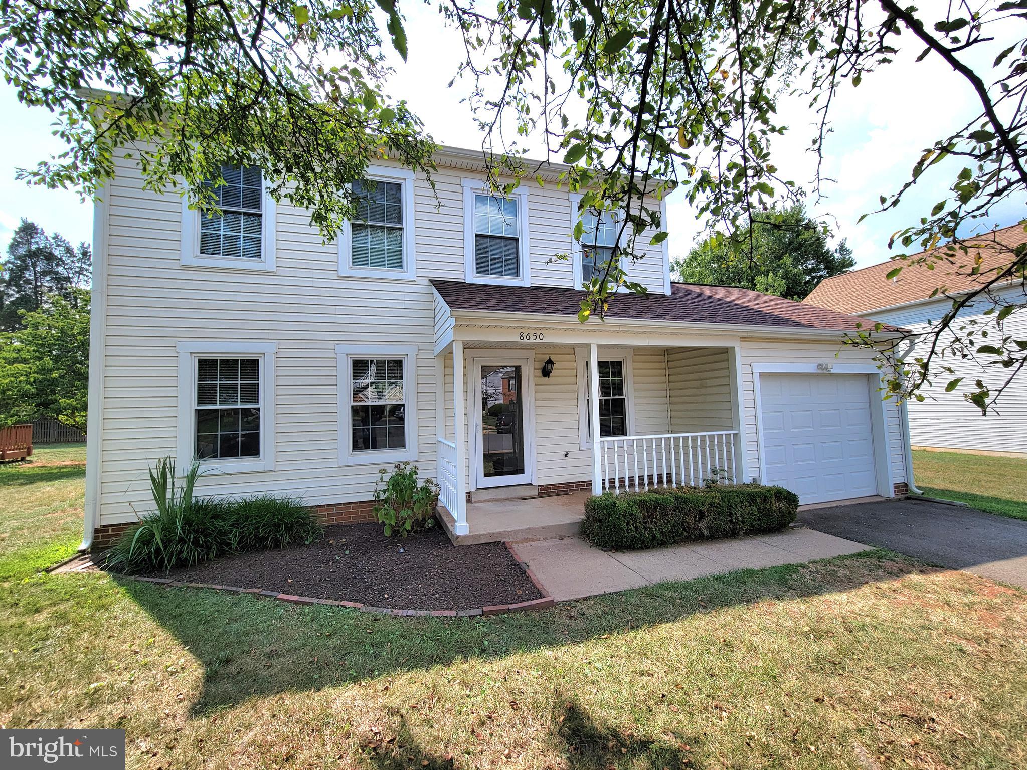 a front view of a house with a yard and potted plants