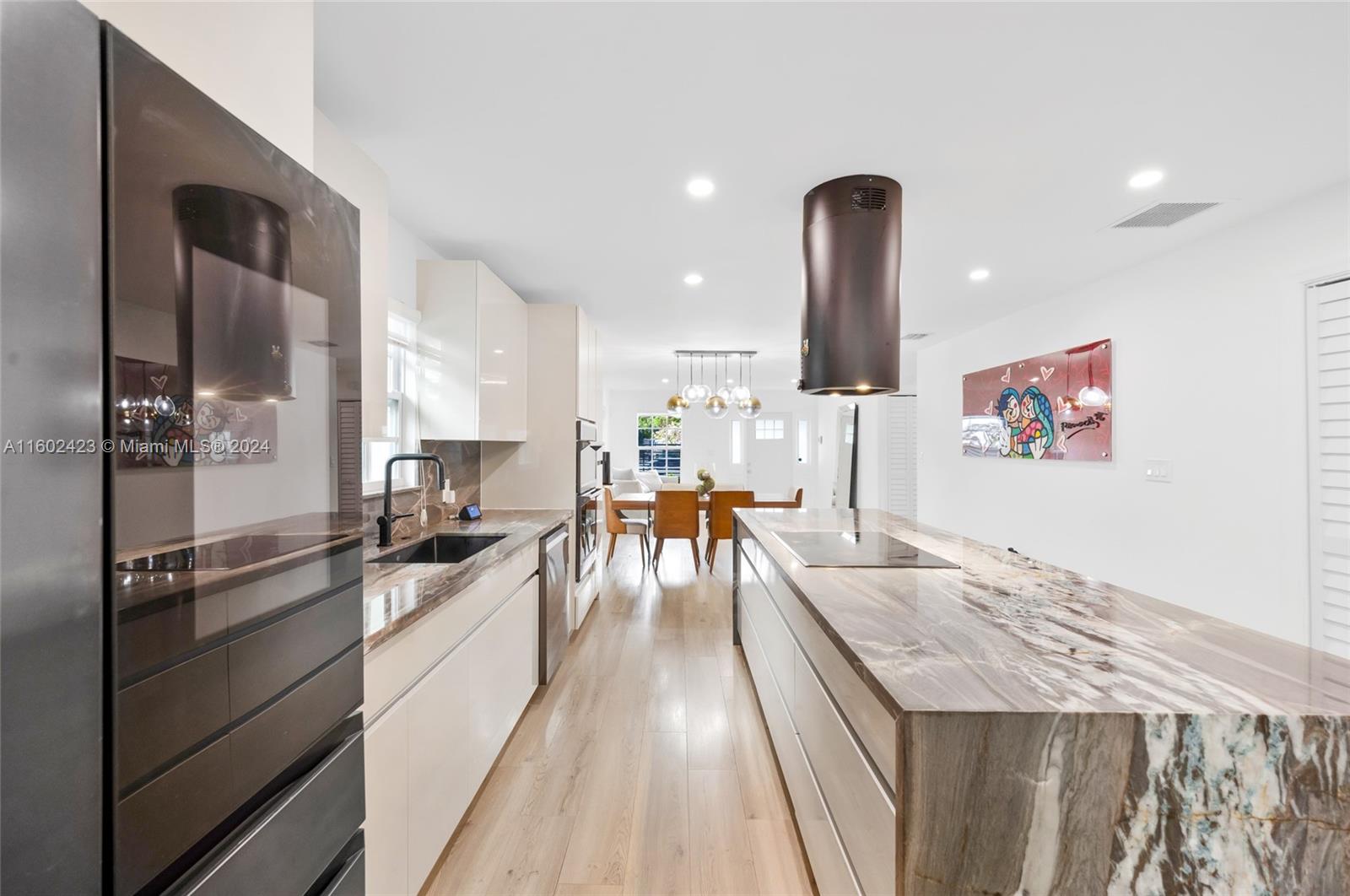 a living room with stainless steel appliances furniture and a kitchen view