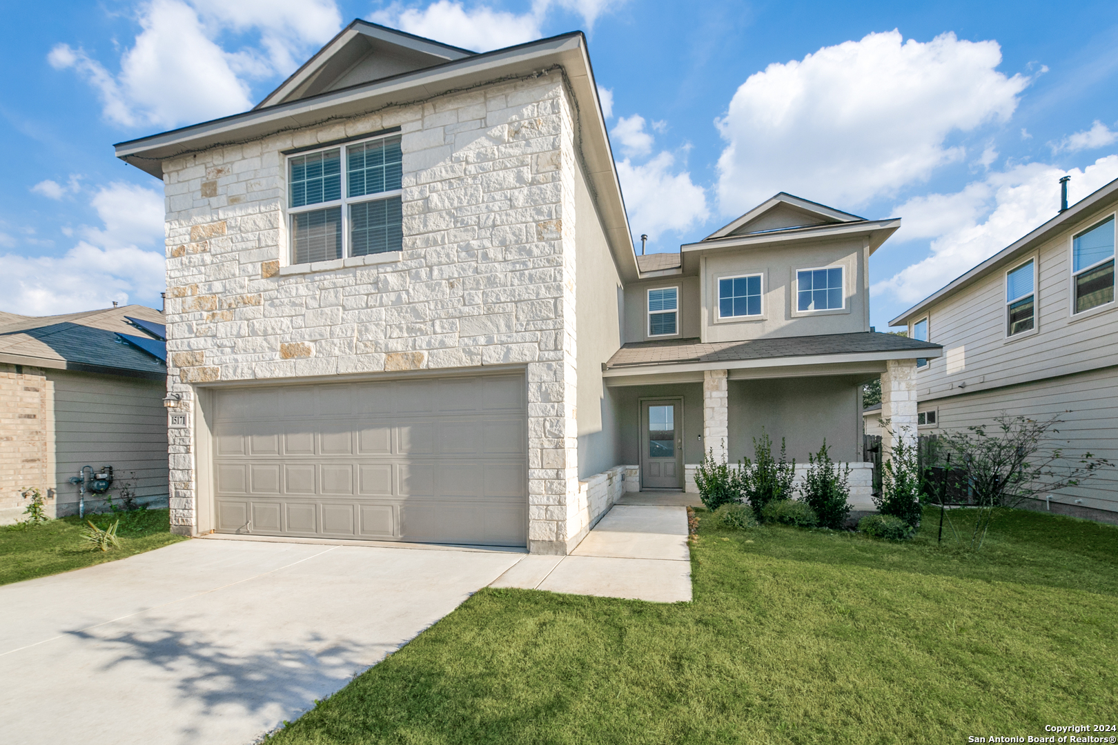 a front view of a house with a yard and garage