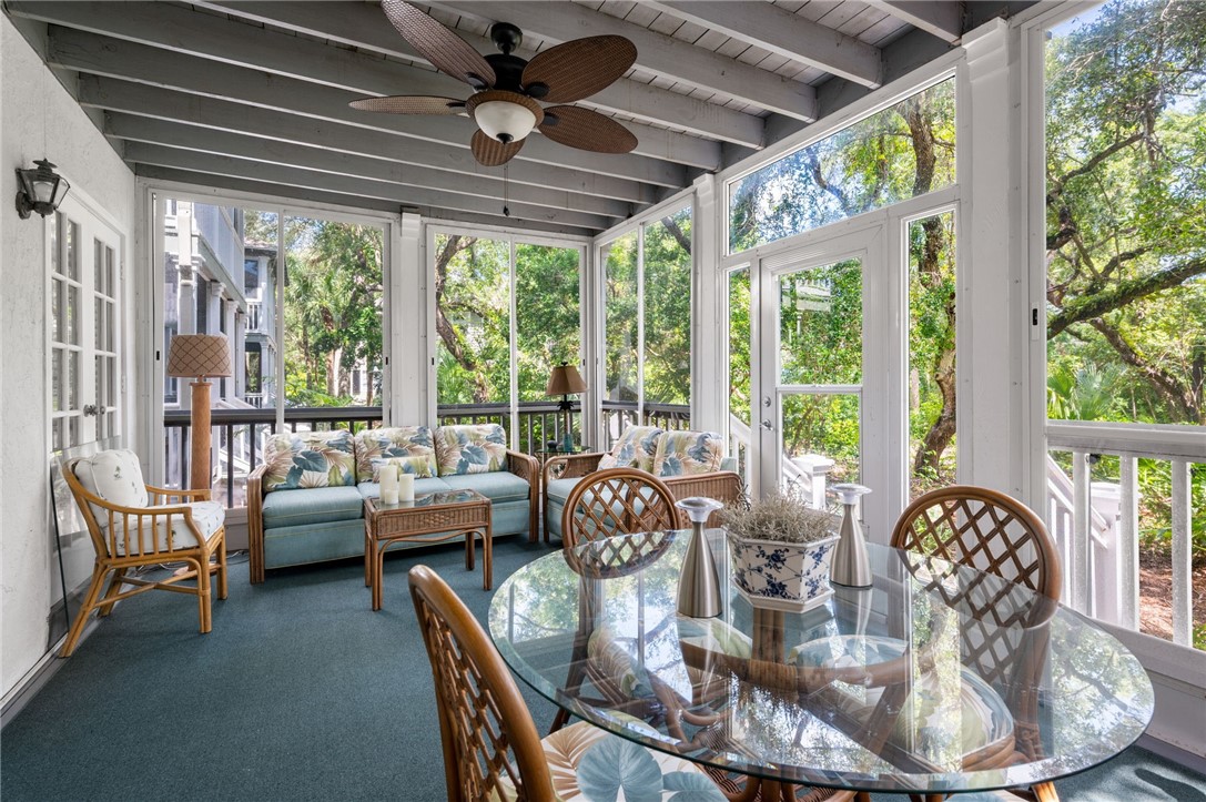 a dining room with furniture large windows and a chandelier