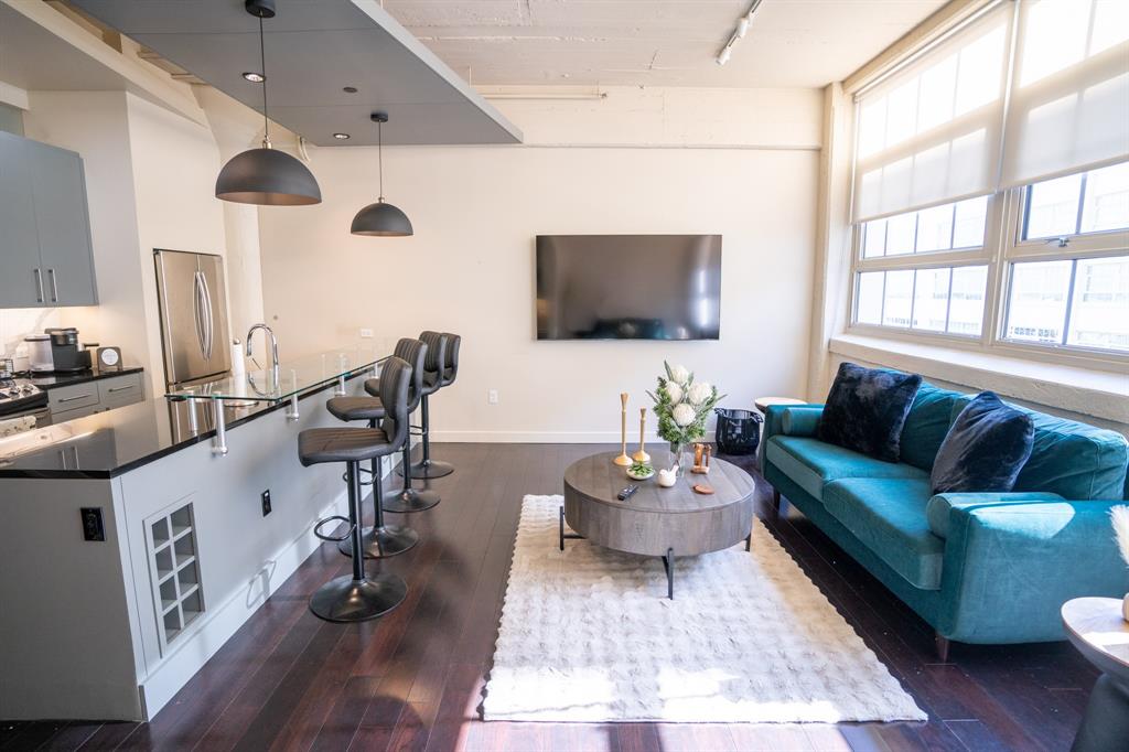 a living room with furniture wooden floor and a flat screen tv