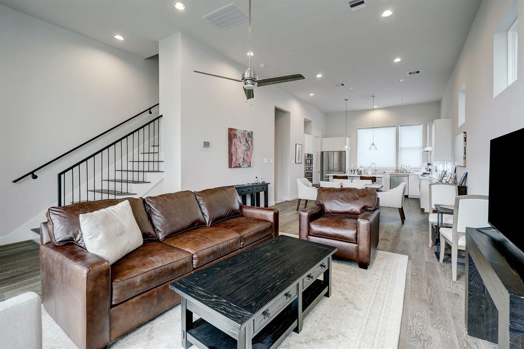 a living room with furniture a flat screen tv and a table