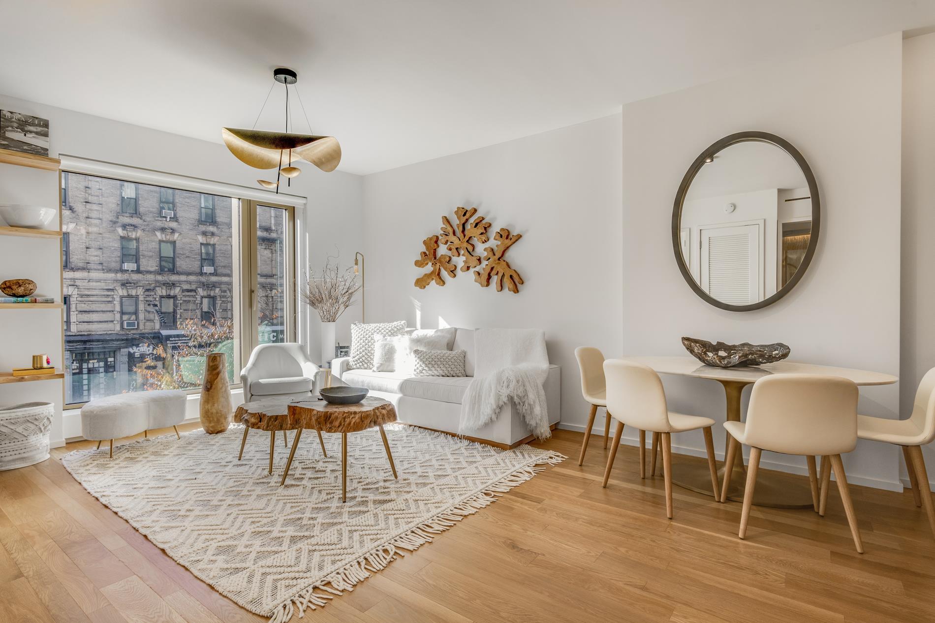 a living room with couches a coffee table and a chandelier with wooden floor