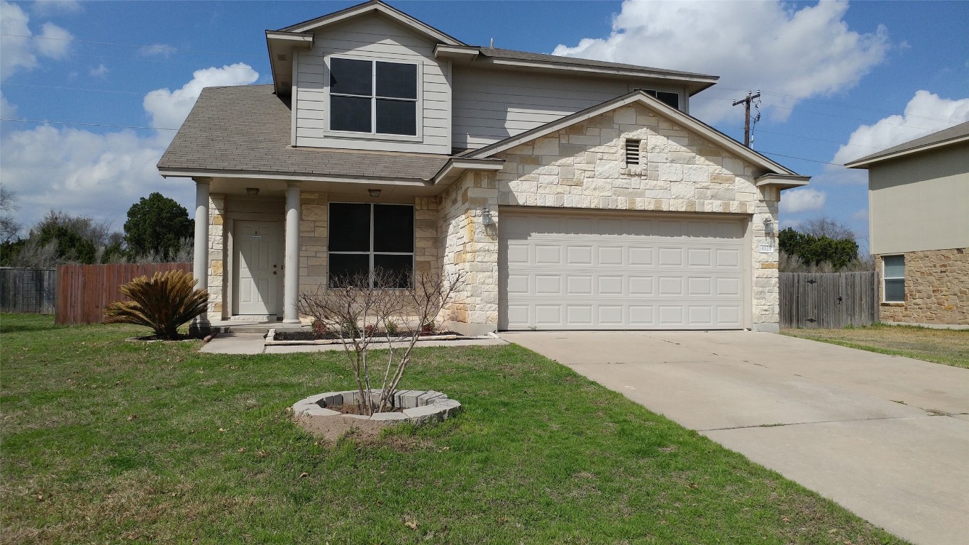 a front view of a house with a yard and garage